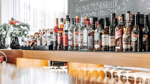 A bar with a variety of liquor bottles and glasses. - HEINhotel Vienna Airport (Schwechat)