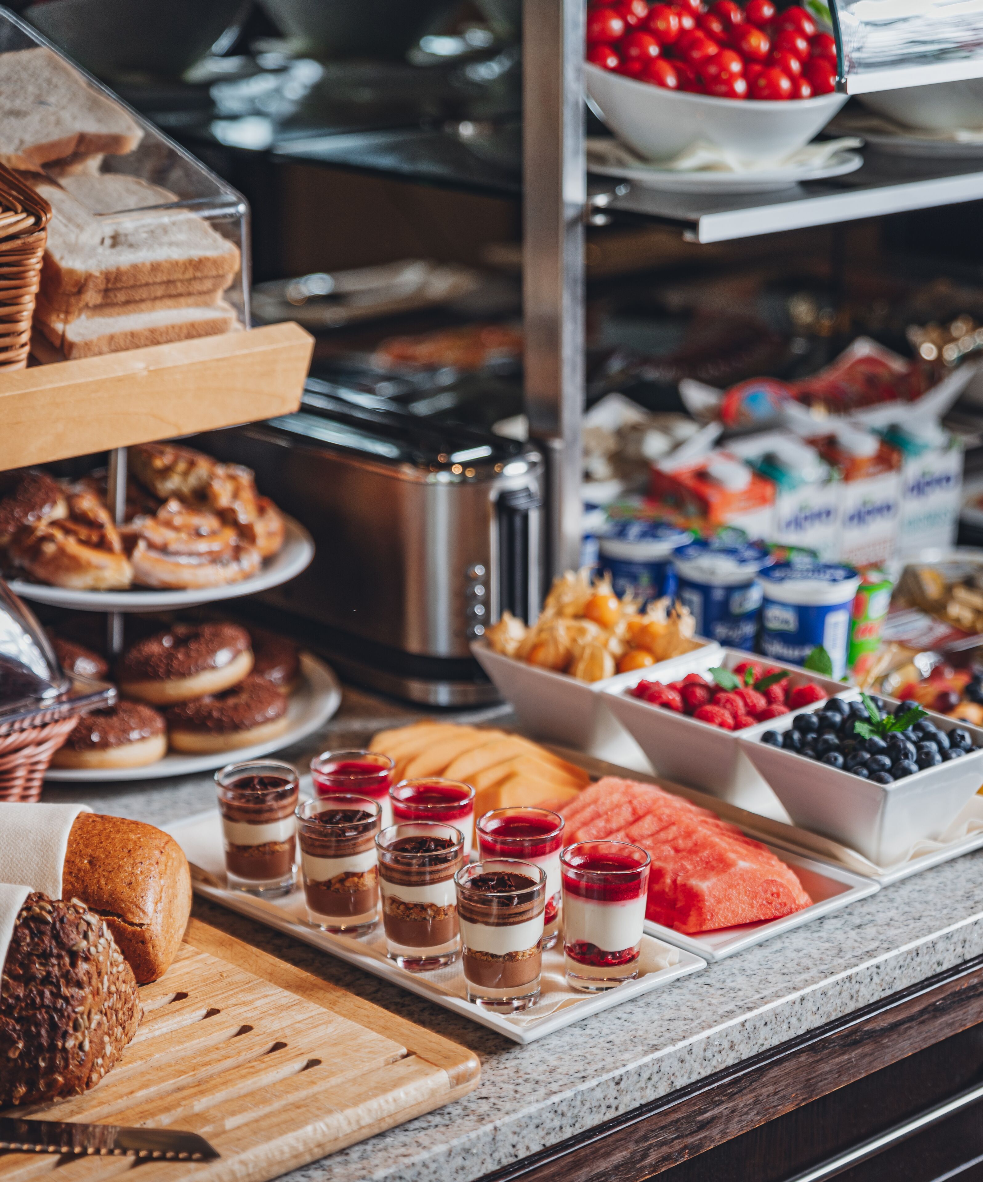 Una vitrina de panadería con diversos productos horneados y postres.