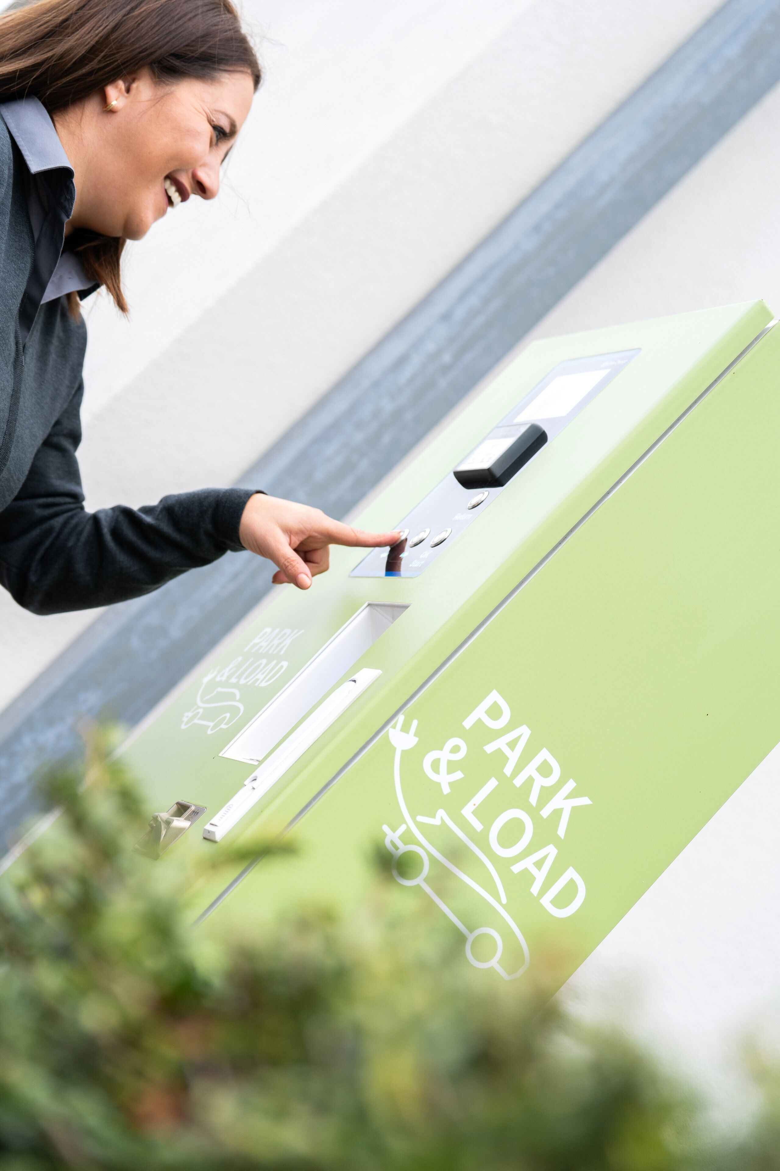 A person using a green parking and loading station.