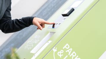 A person using a green parking and loading station.