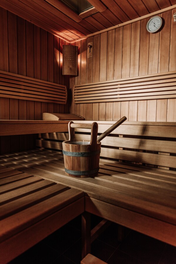 Un sauna en bois avec des bancs et un seau.