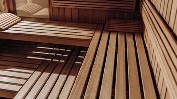 Una sauna de madera con bancos y un banco en primer plano.