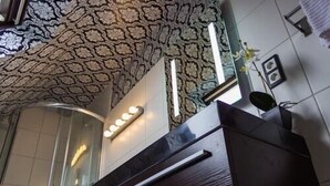 Un área de recepción con techo estampado, un mostrador y una lámpara fijada a la pared.