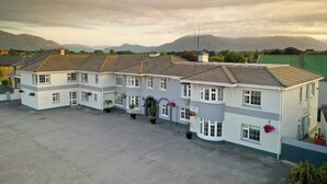 A large, two-story building with a symmetrical facade, multiple windows, and a central entrance. - Castle Lodge (Killarney)