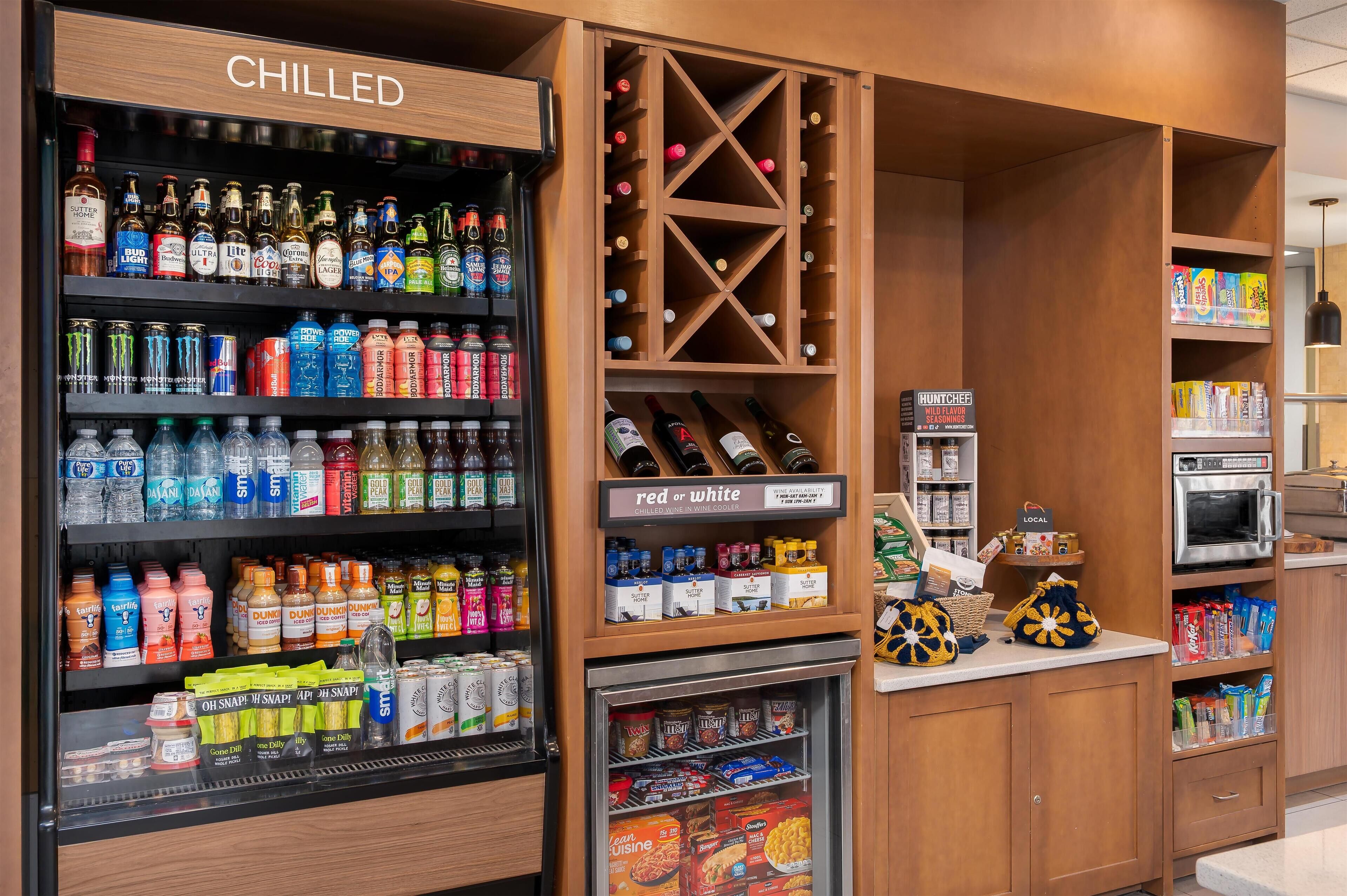 Un refrigerador para bebidas con diversas opciones, una estantería para vinos y una sección refrigerada con aperitivos.