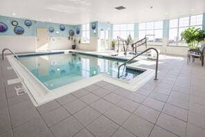 Una piscina techada, sillones reclinables de piscina