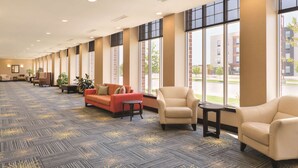 A spacious lobby with a patterned carpet, seating areas, and large windows offering views of the outside. - Hilton Garden Inn Fargo (Fargo)