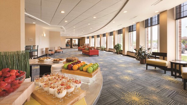 A spacious lobby with a buffet table, seating area, and large windows. - Hilton Garden Inn Fargo (Fargo)