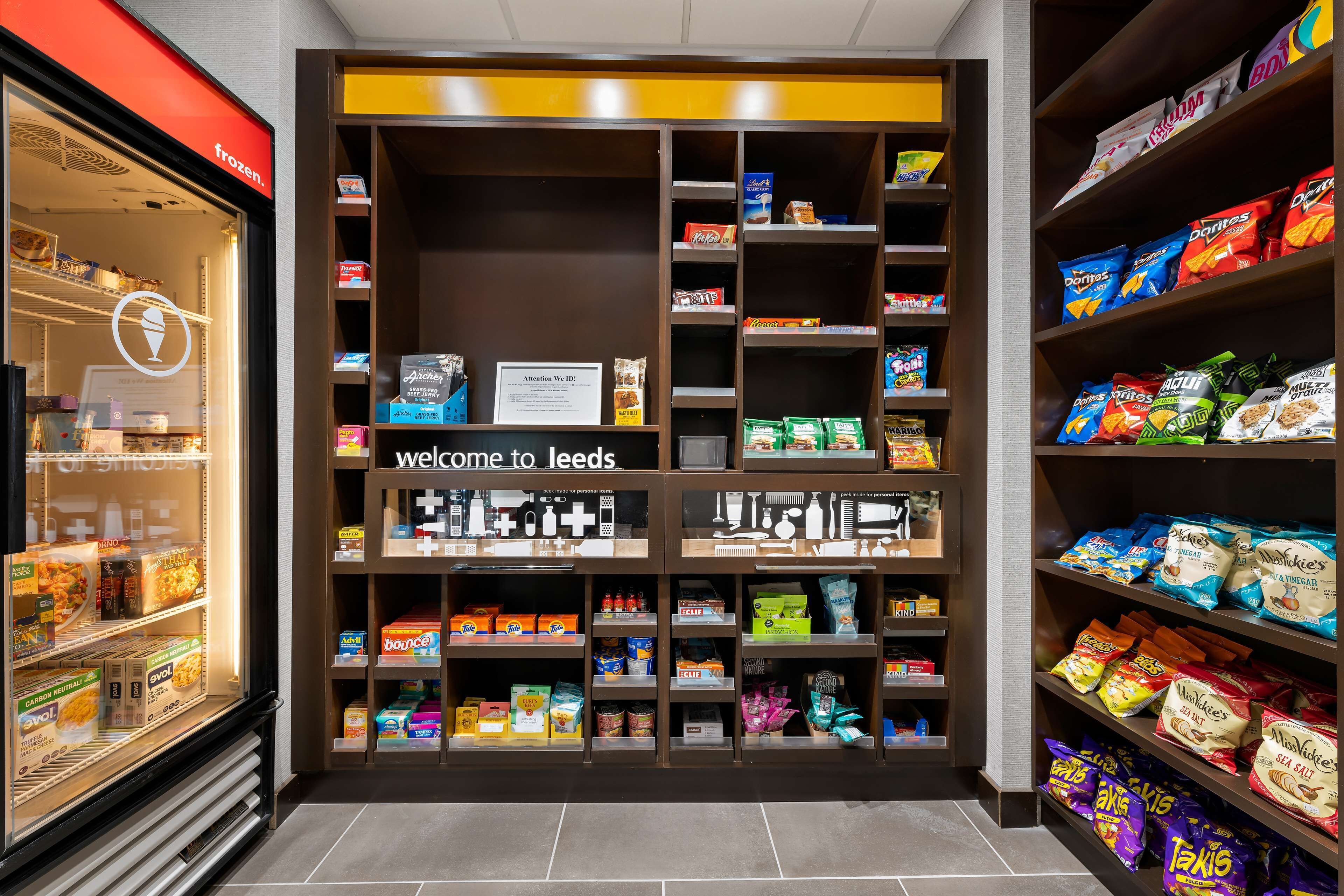 A store interior with shelves stocked with snacks and a freezer section on the left.