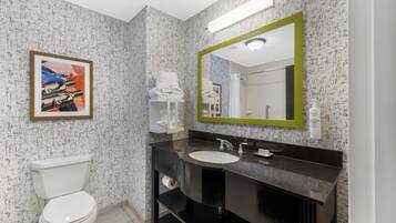 A modern bathroom with a toilet, sink, and mirror.