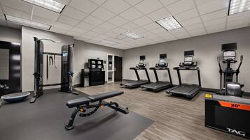 A gym with treadmills, a weight bench, and exercise equipment.