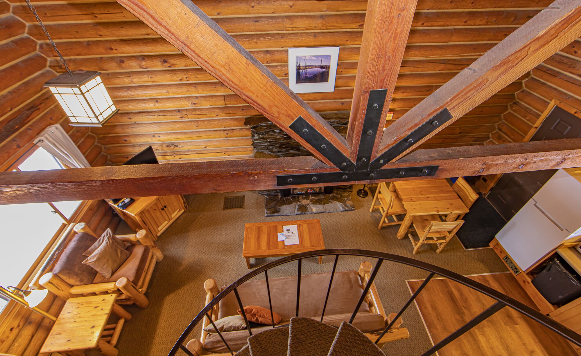 Un intérieur rustique avec des éléments en bois, notamment un escalier en colimaçon, des meubles en bois et un mur en pierre.