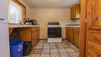 A compact kitchen with wooden cabinets, a stove, and a microwave.