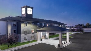 A modern hotel with a covered entrance, multiple windows, and a sign indicating a clearance of 13 feet.