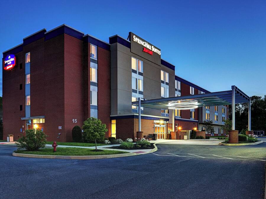 A Marriott Springhill Suites hotel with a brick facade, large windows, and a covered entrance.