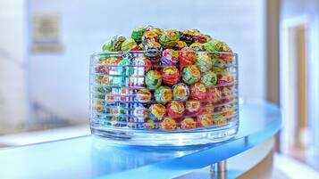 A glass display case filled with assorted wrapped candies on a counter.