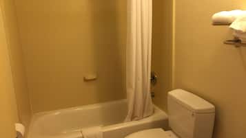 A bathroom with a bathtub, toilet, and a shower curtain.