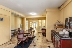A hotel kitchen with a dining area, an exit sign, and a buffet station.