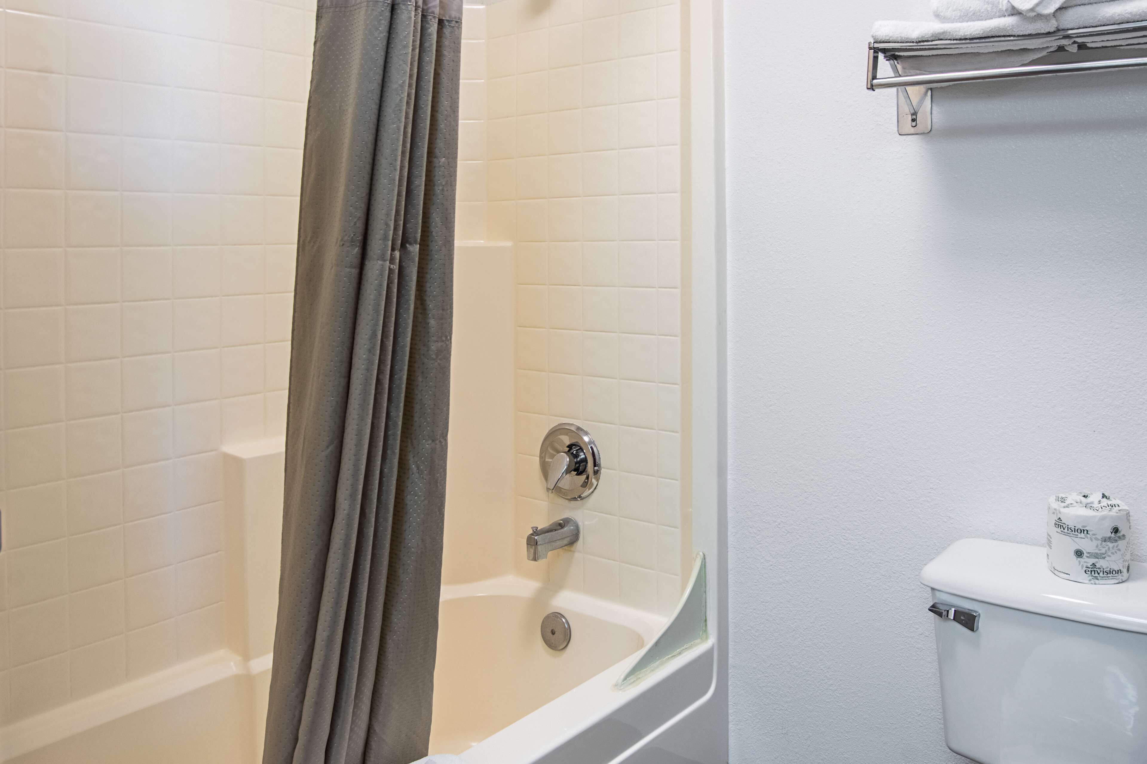 A bathroom with a bathtub, a toilet, and a shower curtain.