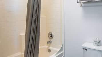 Un baño con bañera, inodoro y cortina de ducha.