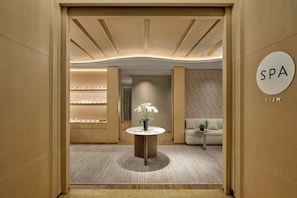 A spa area with a reception desk, a sofa, and shelves with products.