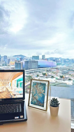 A laptop on a desk with a framed painting and a succulent plant. - Harbour Plaza 8 Degrees (Kowloon)