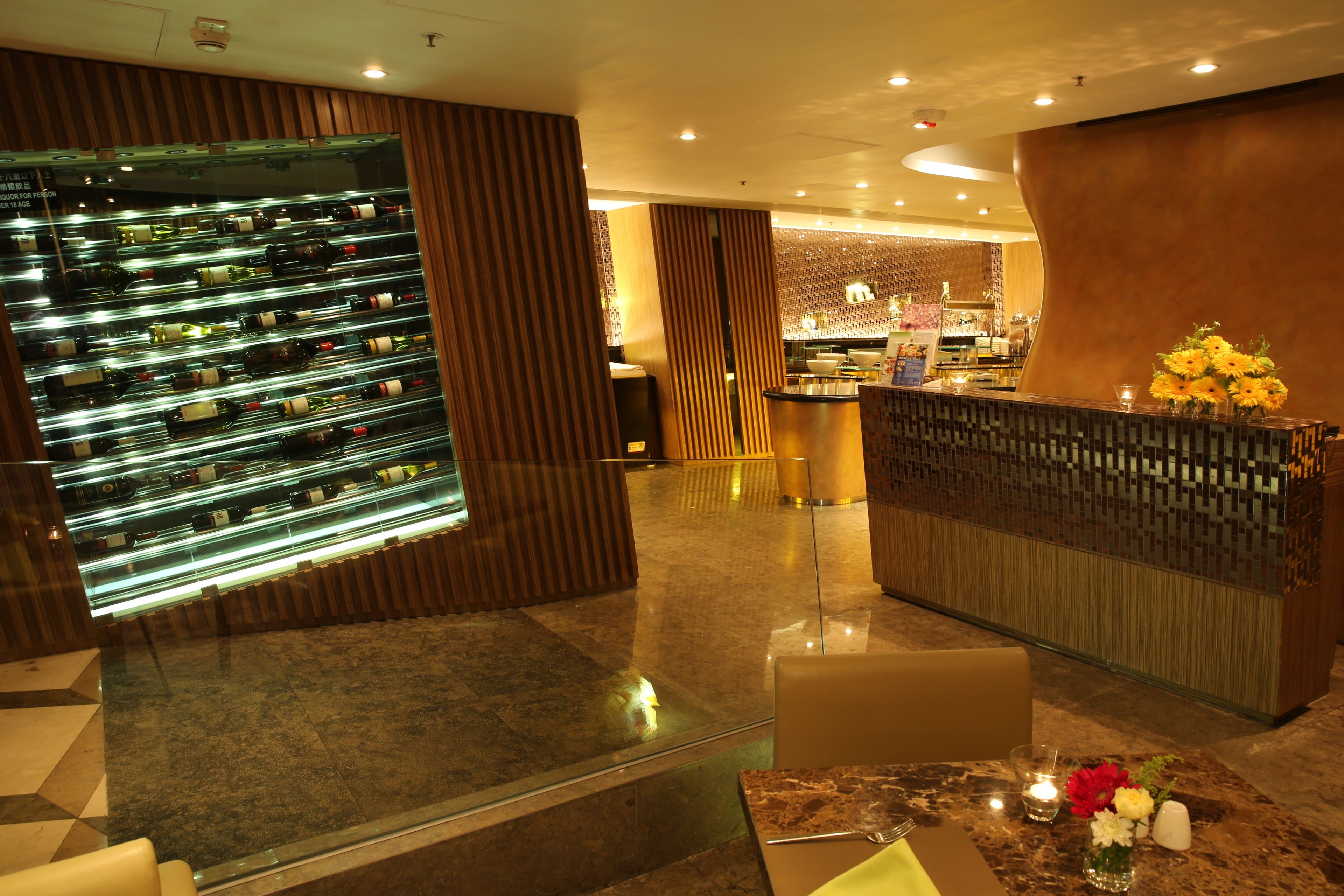 Um hall de hotel moderno com uma seleção de vinhos, uma receção e uma área de estar.