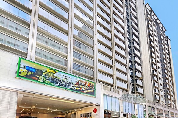 A high-rise building with multiple floors, large windows, and a prominent sign advertising a shopping plaza. - Harbour Plaza 8 Degrees (Kowloon)