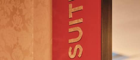 Een rode muur met de tekst 'HERO SUITE' in gouden letters.