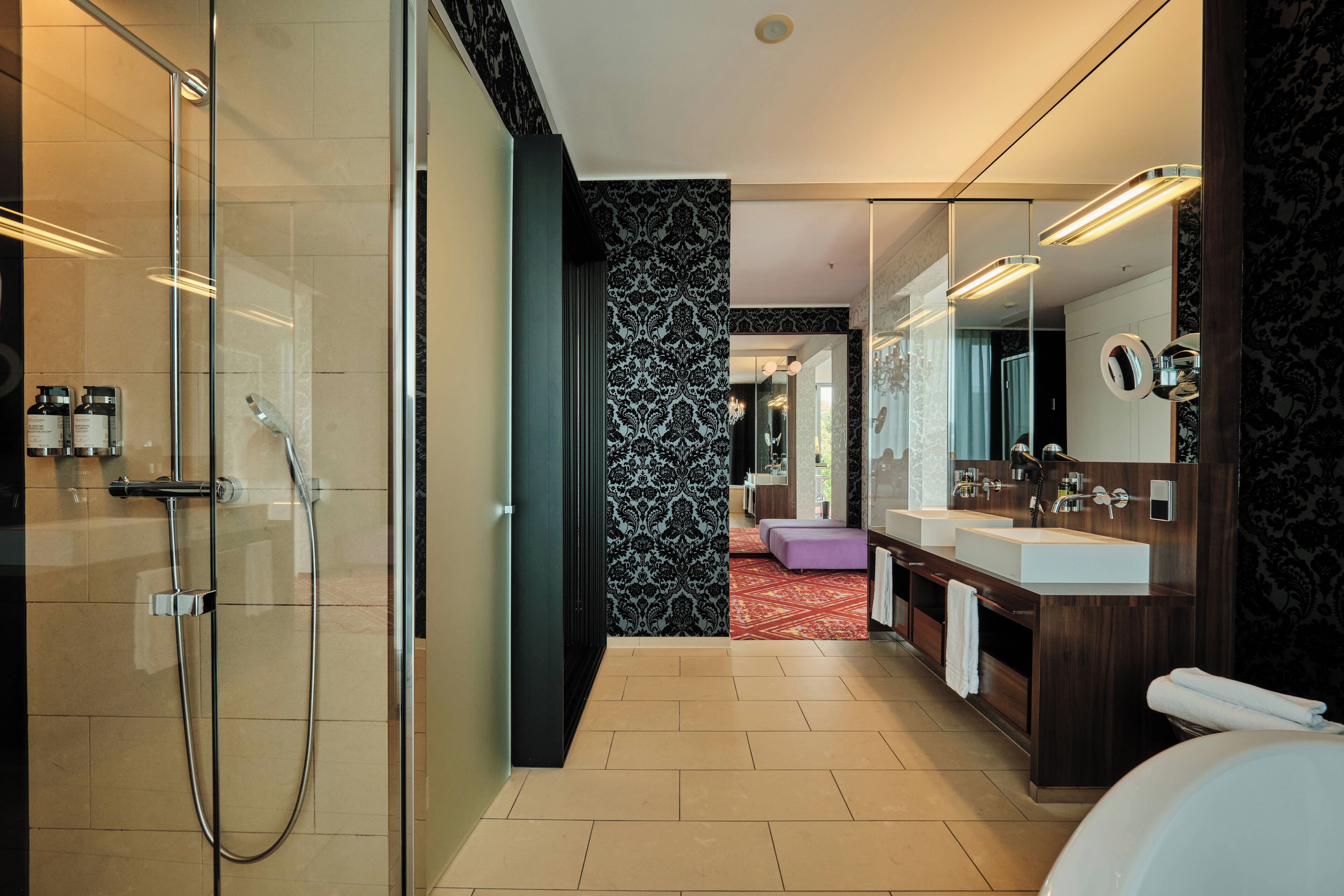 Un baño moderno con cabina de ducha de vidrio, un espejo grande y un mueble de tocador con dos lavabos.