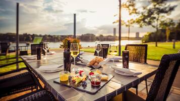 An outdoor dining table with a view of a body of water and greenery in the background.