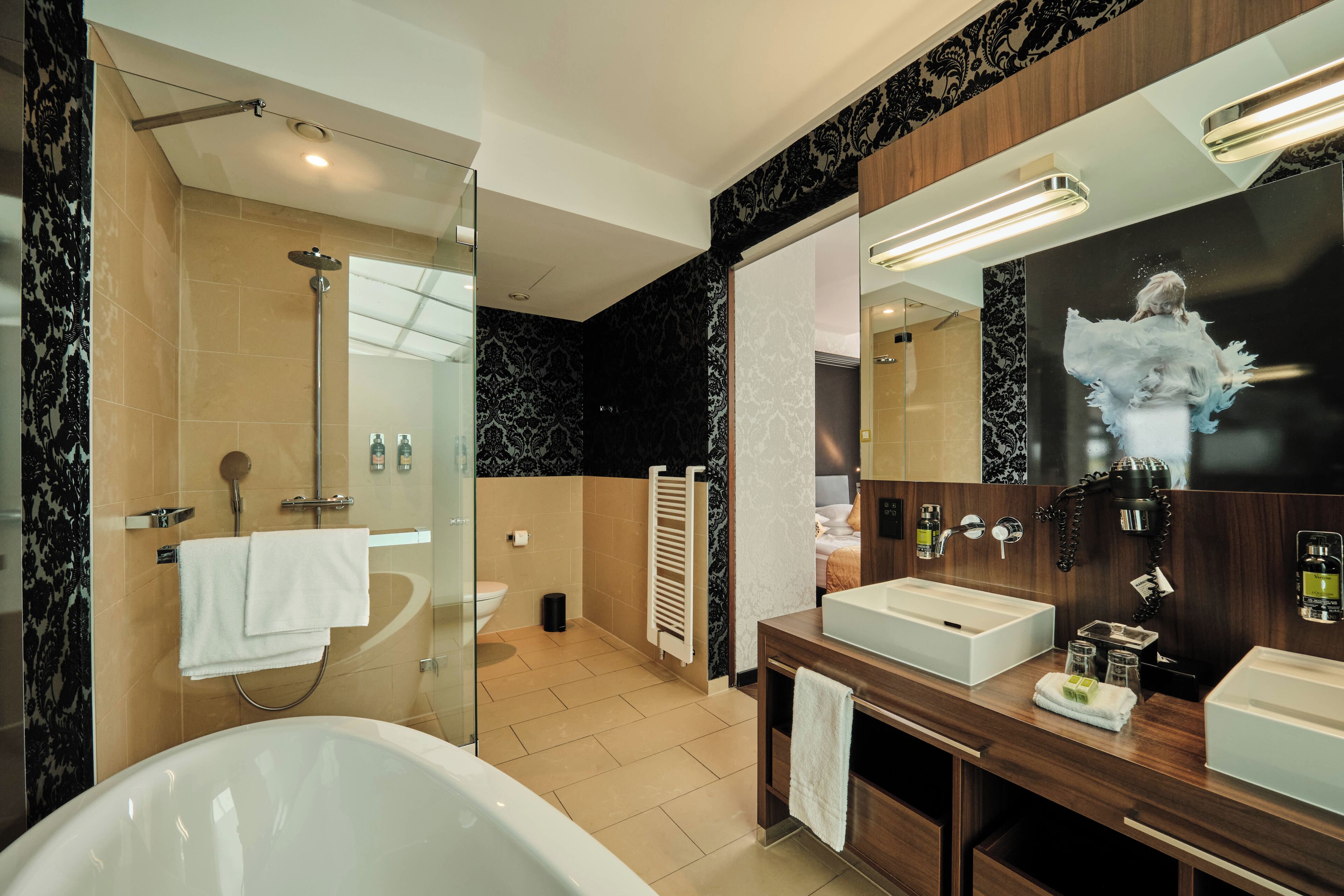A modern bathroom with a bathtub, a large mirror, and a vanity with a sink.