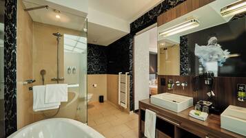 A modern bathroom with a bathtub, a large mirror, and a vanity with a sink.