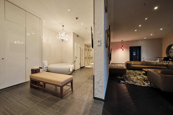 A modern hotel lobby with a seating area, a large bathtub, and a chandelier. - Kameha Grand Bonn (Bonn)