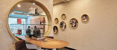A modern interior with a round mirror, a wooden desk, and framed pictures on the wall.