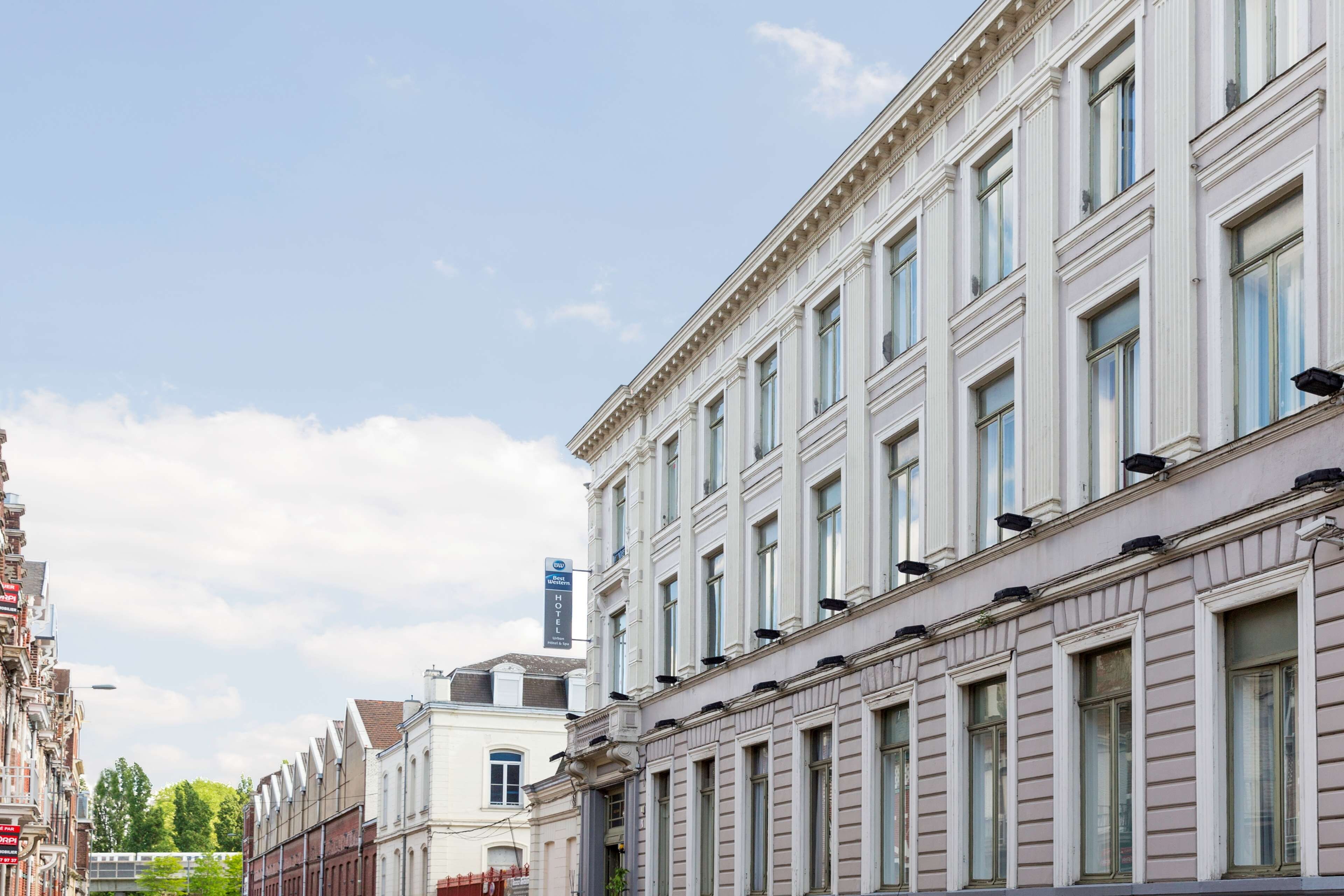 Una hilera de edificios históricos con arquitectura clásica, incluyendo un hotel con un letrero que indica que pertenece a la cadena Best Western.