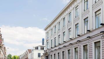 Una hilera de edificios históricos con arquitectura clásica, incluyendo un hotel con un letrero que indica que pertenece a la cadena Best Western.