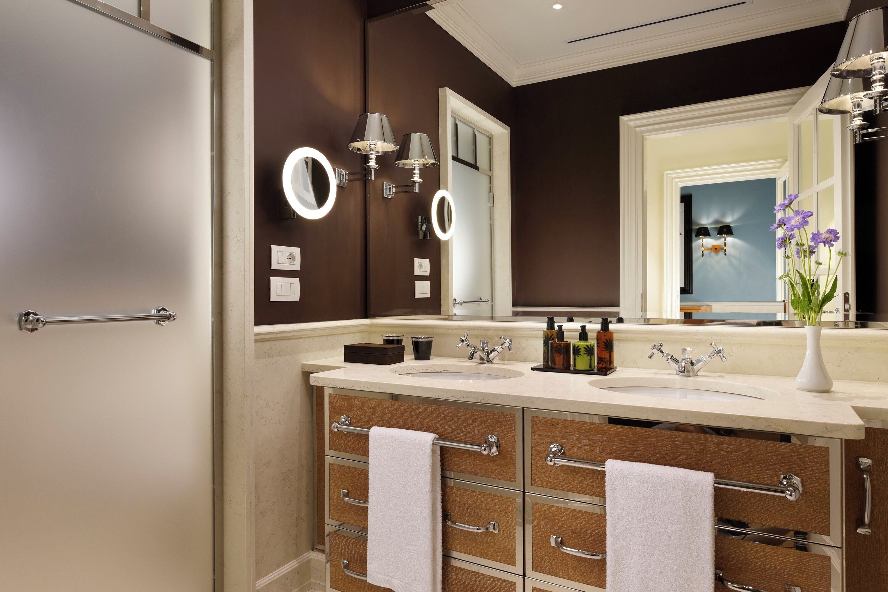 Un baño moderno con dos lavamanos, un espejo grande y un mueble tocador con cajones.
