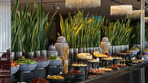 Un bufé con diversos alimentos y plantas decorativas.
