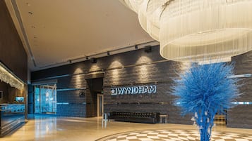 Welcome to our lobby, featuring a reception desk, comfortable seating area, and a striking abstract sculpture.