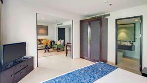 A modern hotel room with a large bed, a television, a mirror, and a view of the living area. - Away Bali Legian Camakila Resort (Legian)