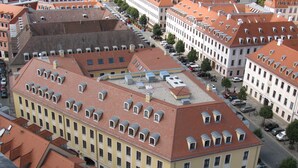 A multi-story building with a red-tiled roof, multiple windows, and a central courtyard. - Relais & Châteaux Hotel Bülow Palais (Dresden)