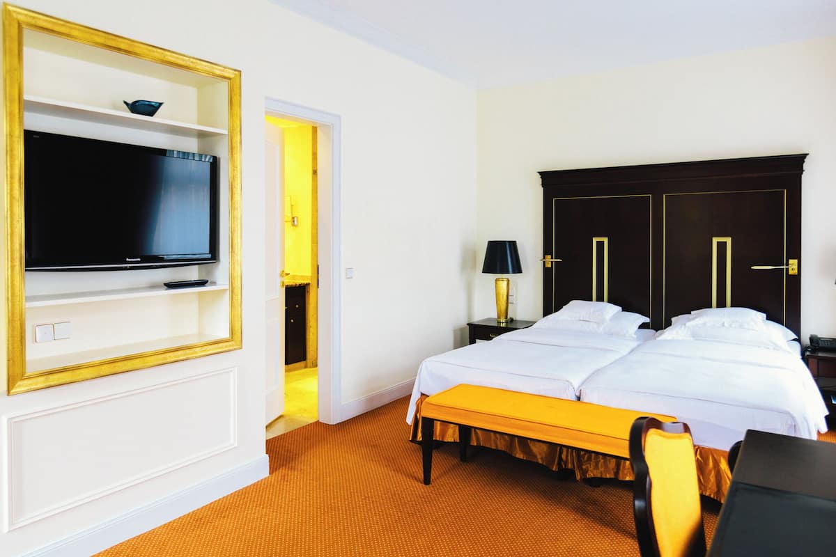 Una habitación de hotel con cama, televisión, escritorio y silla.