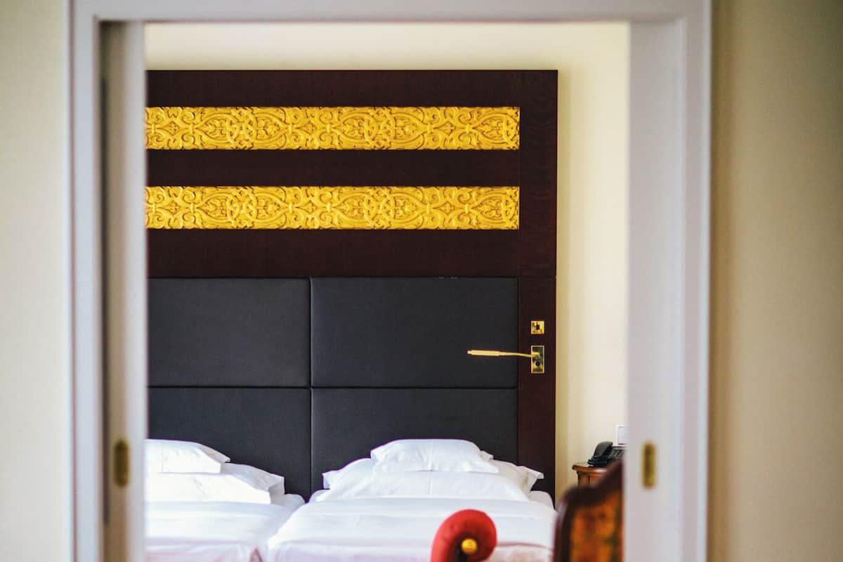 Una habitación de hotel con una cama, una silla y una mesa con un jarrón de flores.