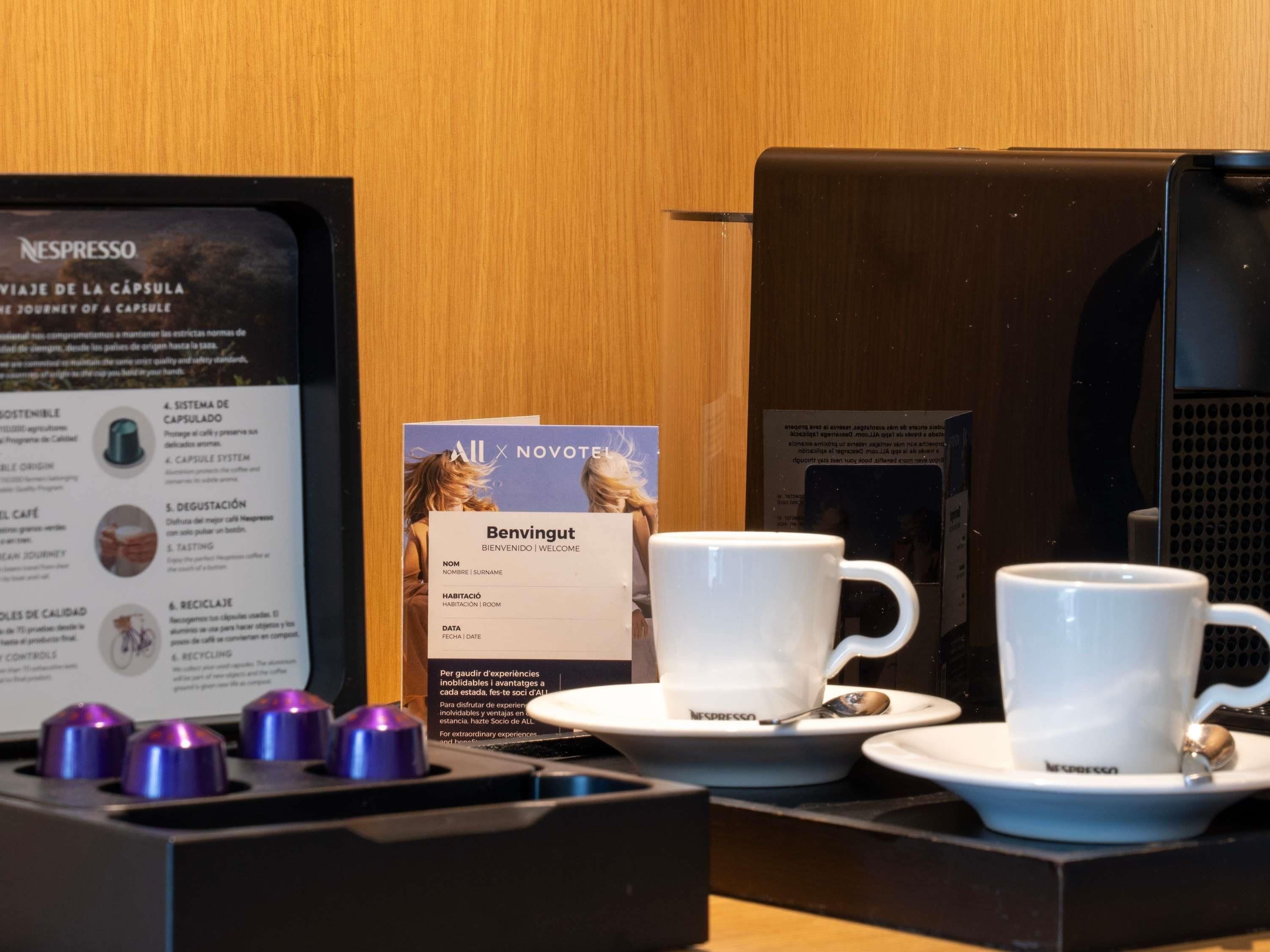A coffee machine, two cups, and a sign with information about the coffee experience.