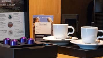 Una cafetera, dos tazas y un cartel con información sobre la experiencia del café.