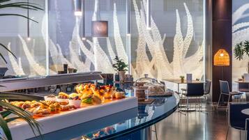 Uma área de buffet com diversas opções de comida e um design de interiores moderno.