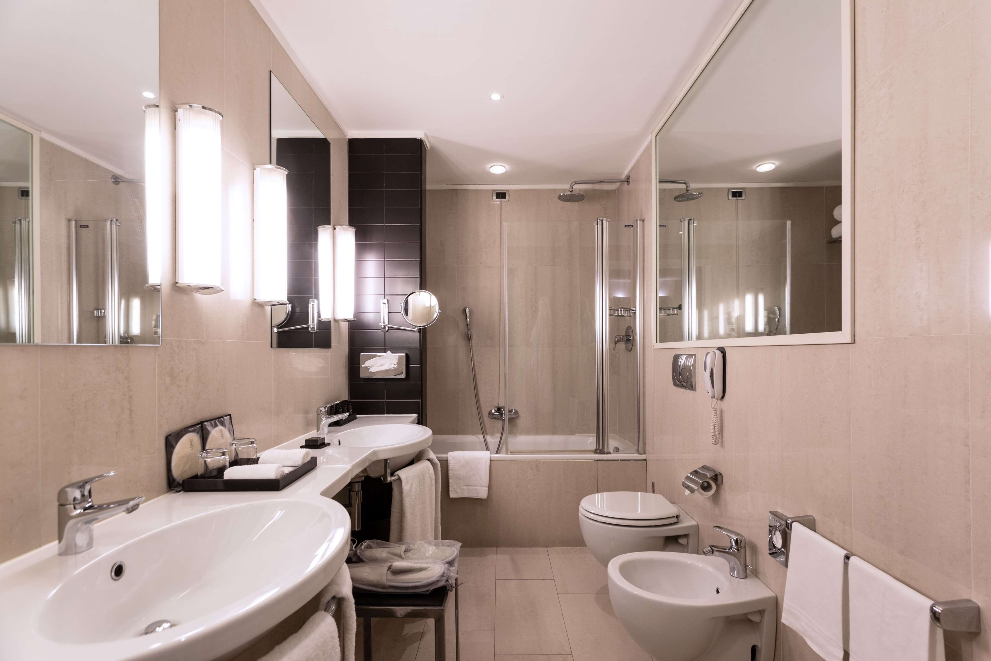 Un baño moderno con un lavamanos grande, un inodoro, un bidé y una zona de ducha.