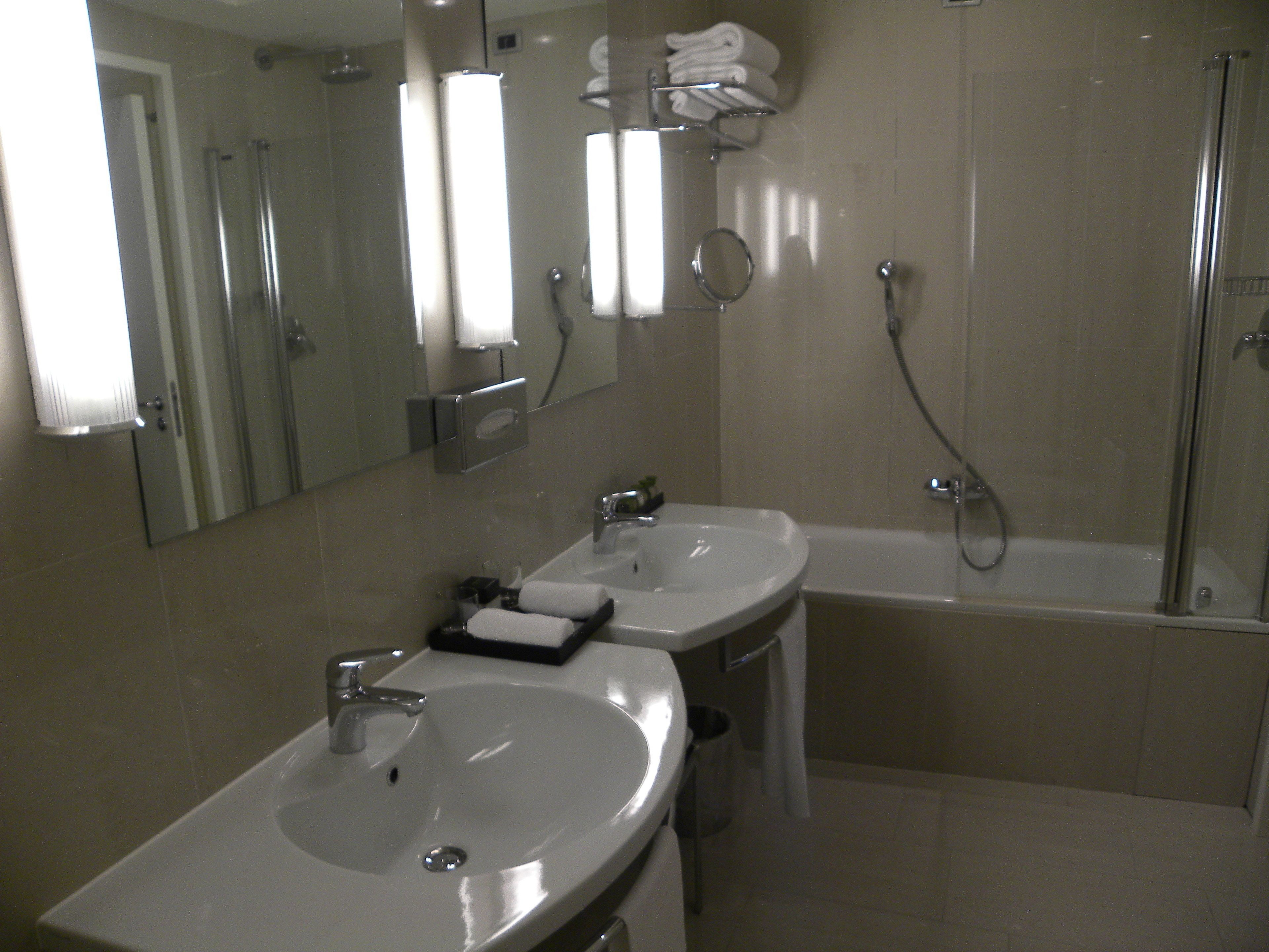 Un baño con dos lavamanos, un espejo y una ducha.