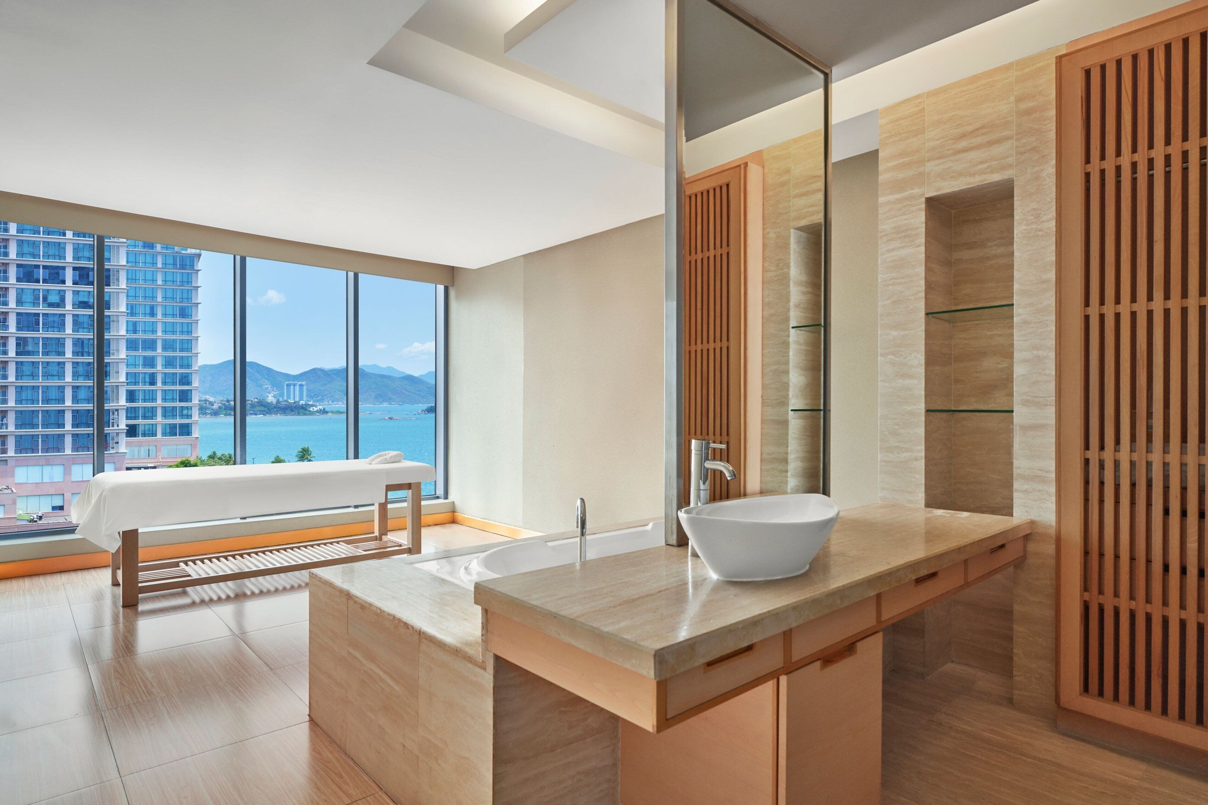 A modern bathroom with a large window, a bathtub, and a large mirror.